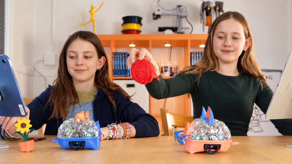 Two students experimenting with SpikerBot robots and tablets