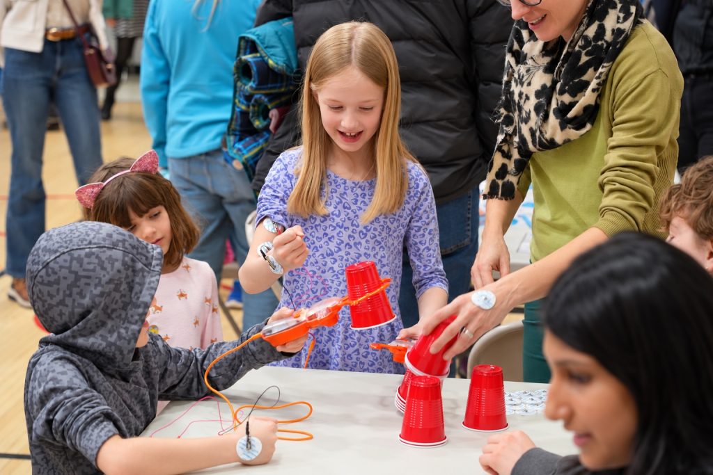 Children trying a hands-on neuroscience activity with an educator